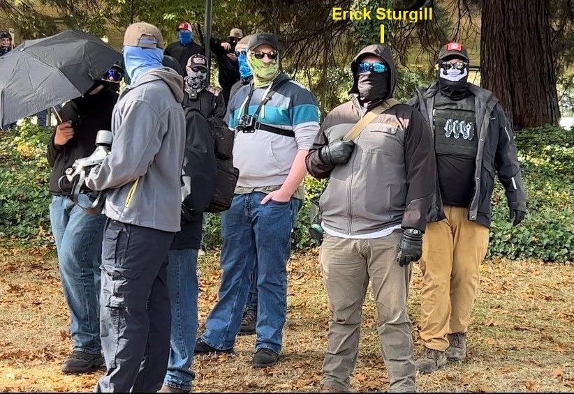 Picture of Erick with other RCN members; he is wearing khaki pants and his face is covered with a black gaiter with blue sunglasses
