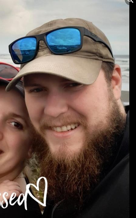 picture of Erick with his girlfriend by the beach; he is wearing a hat and sunglasses