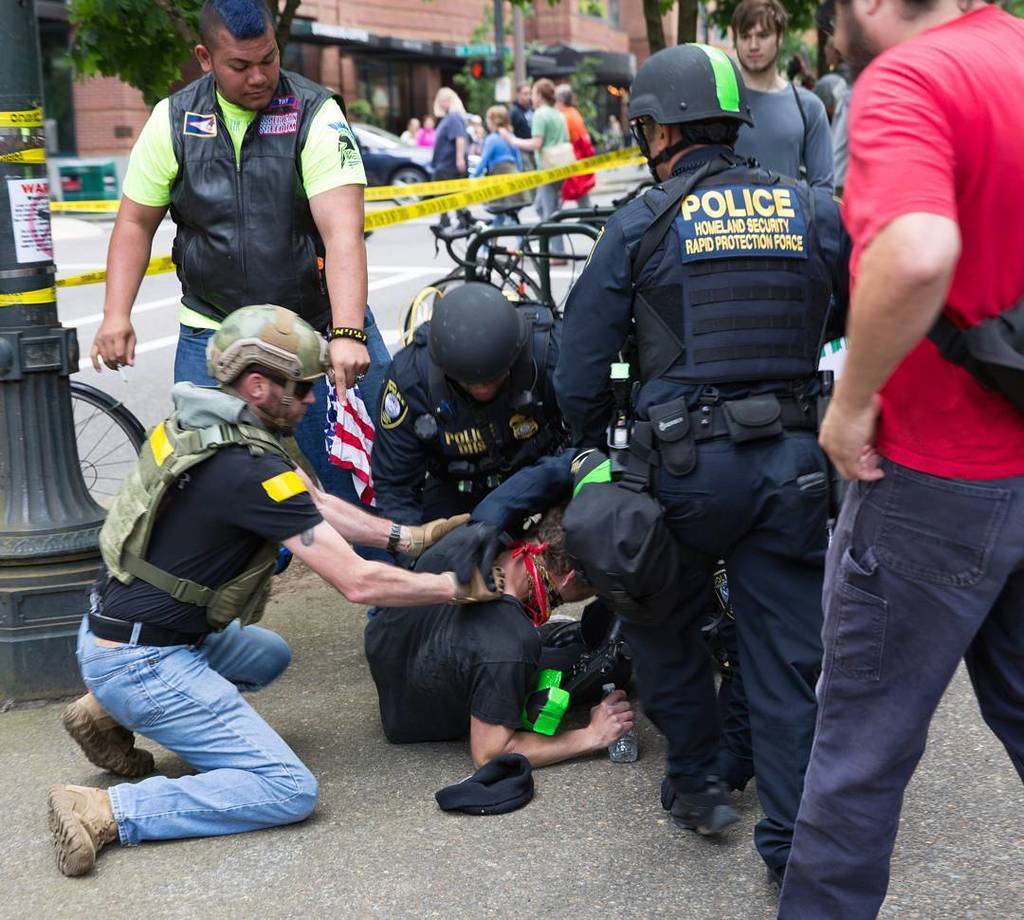 A III% militia member aids police and DHS agents in the arrest of an anti-fascist protester at Joey Gibson’s rally on 6/4/2017 in Portland. This instance of police / federal agent / militia collaboration is currently under investigation by the U.S. Attorney’s office. We aren’t holding our breath