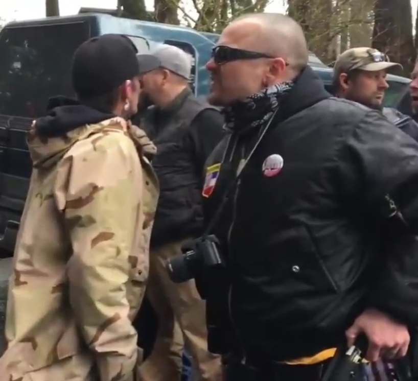 _KKK Imperial Wizard and National Socialist Movement member Steven Shane Howard reaches for his knife while hurling verbal abuse at an anti-fascist demonstrator on 3/4/2017, soon after this, Militia members circled around him with their backs to him to protect him