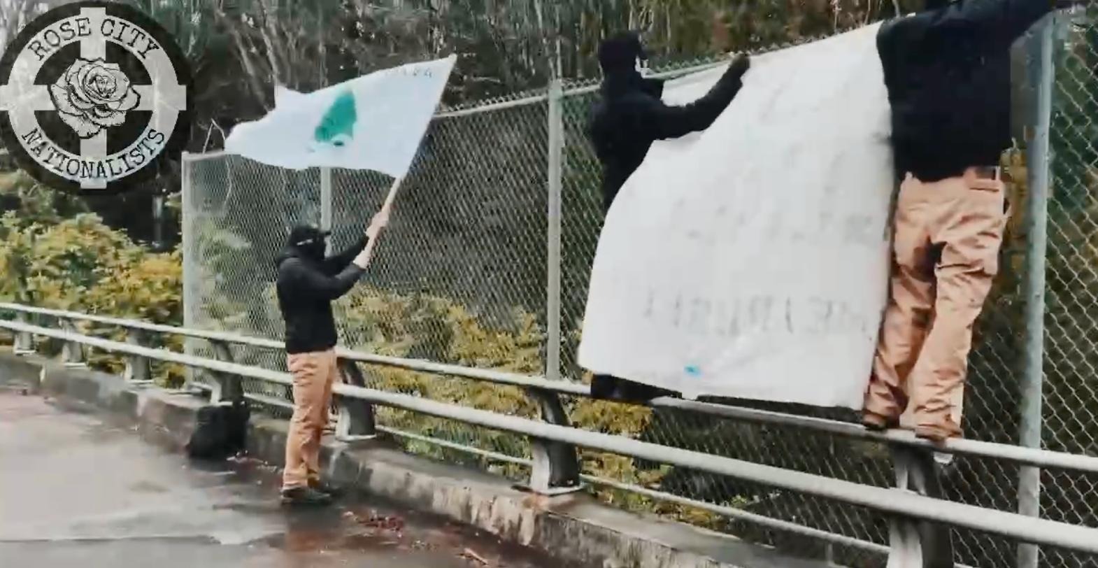 Picture of RCN doing a banner drop off of I-205 while Michael Dorsey holds an 'Appeal to Heaven' flag.